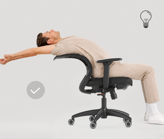 Man stretching comfortably on the ErgoStretch chair without leaving his seat, staying focused and productive.