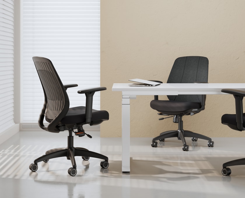 ErgoStretch office chairs positioned at desks in a bright, modern office with white blinds.